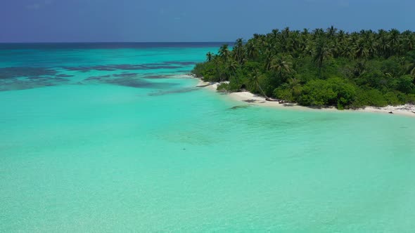 Tropical fly over tourism shot of a white sand paradise beach and blue sea background in vibrant 4K alt