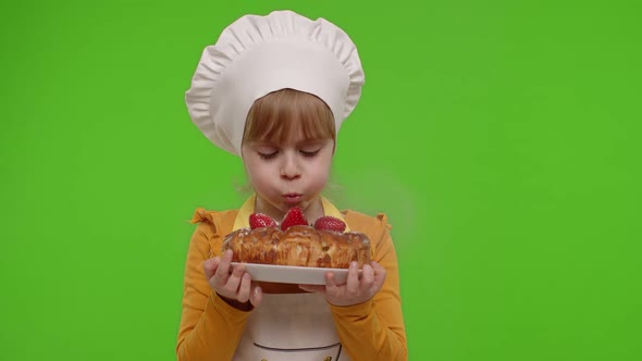 Child Girl Kid Dressed As Cook Chef Sprinkle Strawberry Cake with Icing Sugar Chroma Key Background alt
