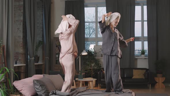 Female Best Friends Dancing On Bed alt