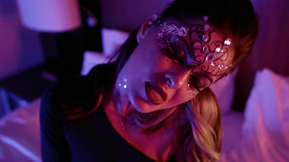 Sexy Lady with Vivid Makeup with Crystals and Fake Lashes in Dark Bedroom alt
