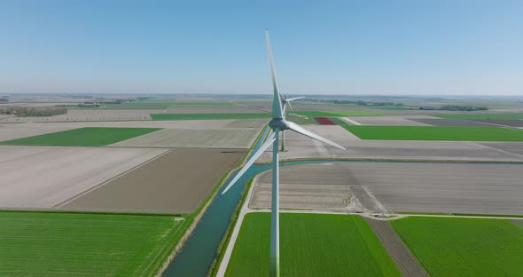 Wind turbines spinning and generating clean energy in Holland, with classic water canal alt