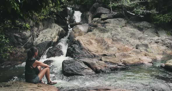 Thailand Jungle River Fall Woman Sits on Rock By Waterfall and Admires of Than Sadet National Park