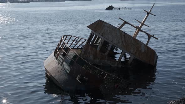 sunken boat near the rocks	 alt