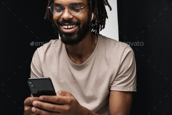 Happy laughing guy using mobile phone while listening music Stock Photo by  vadymvdrobot