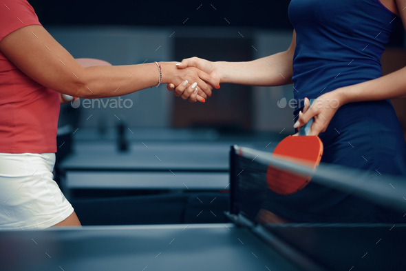 Women shake hands before table tennis match