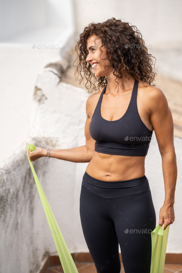 Middle-aged woman with fitness body working out on the terrace of her house