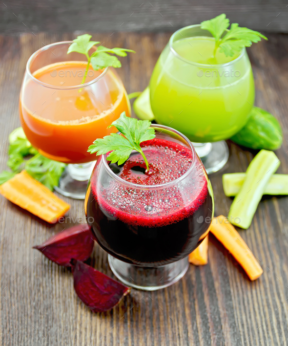 Juice beet and cucumber in wineglass on dark board - Stock Photo - Images