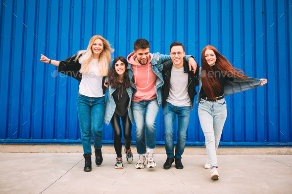 Group of four young diverse friends in jeanse outfit look carefree, young and happy on city's