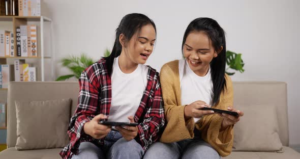 Asian twin girls playing smartphone on phone alt