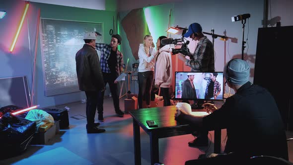 Film Shooting Backstage: Film Director Showing African Star How To Threaten a Gun in Movie Scene alt