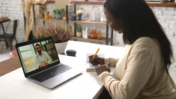 AfricanAmerican Woman Talking Online From Home with a Doctor Having a Virtual Medical Checkup