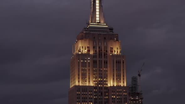 AERIAL: Flying Up the Empire State Building at Night in Manhattan Surrounded By Skyscrapers in Busy alt