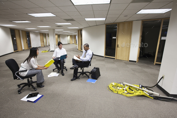 Three business people sitting making plans for a new office layout.
