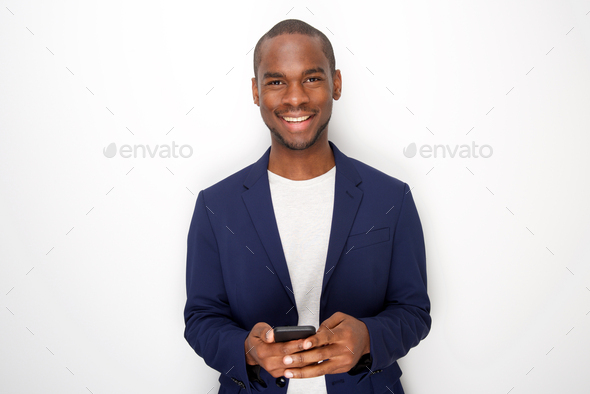 Portrait of cool young black man smiling with mobile phone against white background