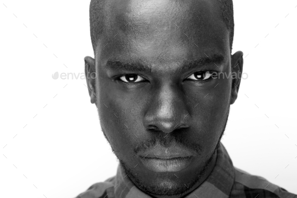 Close up black and white of young black man staring