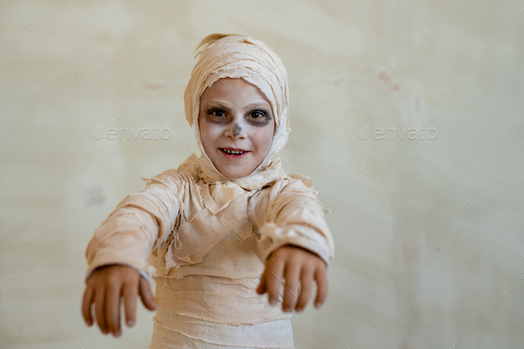Boy in mummy costume acting like zombie - Stock Photo - Images