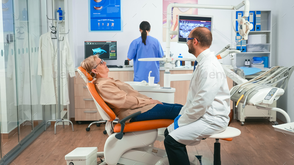 Assistant preparing patient for dental intervention