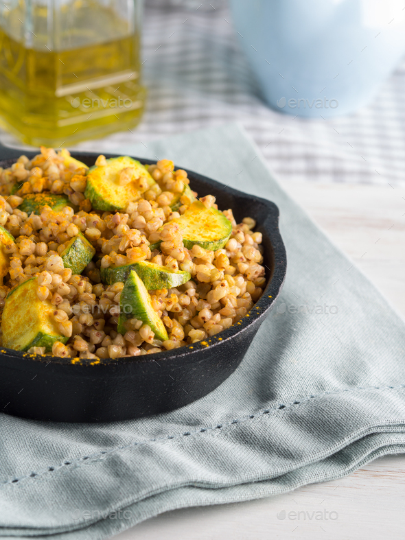 Buckwheat with zucchini and turmeric in skillet Stock Photo by tenkende