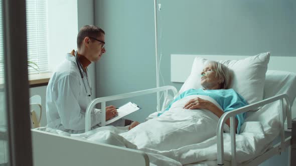 Doctor Working with Senior Patient in Hospital Ward alt