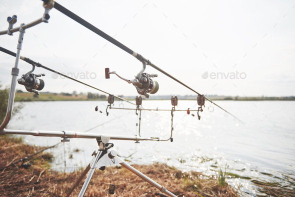 Carp fishing rods standing on special tripods. Expensive coils and a radio system of crochet