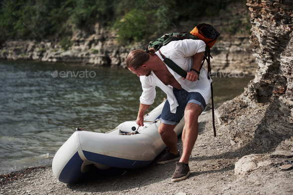 A young man is traveling with a backpack using a boat. The way of life of travel and nature with