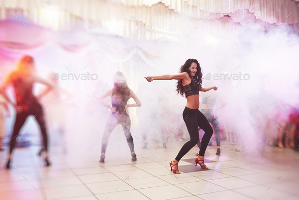 Hot women latin dancer show the performance in a full people lounge, beautiful light and smoke