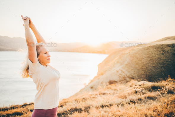 Woman practicing Yoga, meditation close to the sea. - Stock Photo - Images