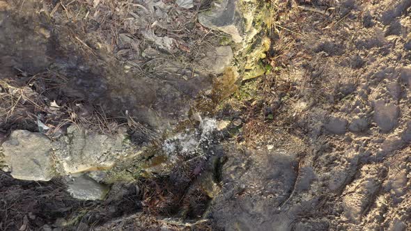 Above the artificial waterfall in the woods 4K drone video alt