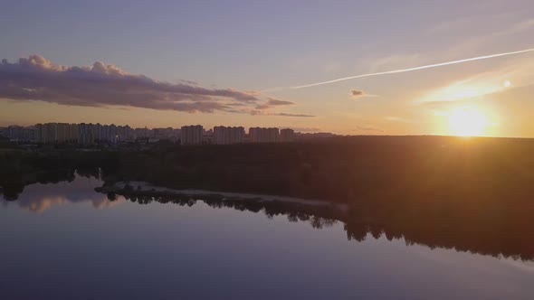 Flight Over the Lake During Sunset Overlooking the City with Beautiful Clouds, Ukraine Kiev