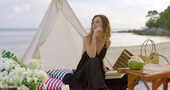 Brunette Female Enjoys Book Reading By Seating on the Beach Camp alt