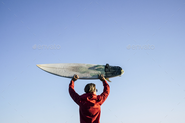 blonde surfer from rear view take the surf table up on his head