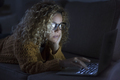 Dark portrait of adult woman use computer at home by night - PhotoDune Item for Sale