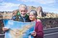 beautiful caucasian aged senior couple man and woman people traveling using old style paper map - PhotoDune Item for Sale