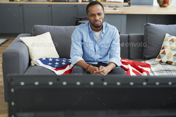 Disappointed man in front of TV - Stock Photo - Images