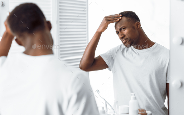 Black Guy Examining His Head Searching Gray Hair In Bathroom
