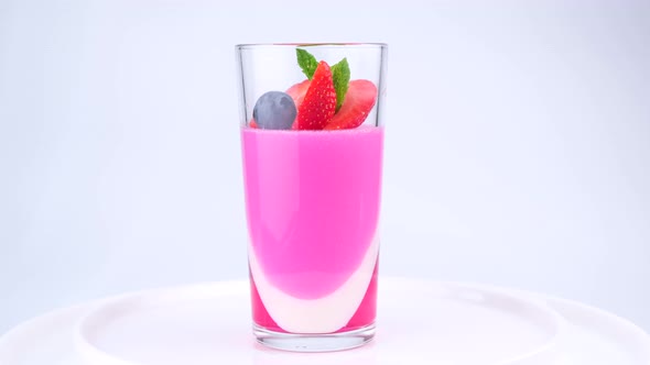 Fruit Jelly with Strawberries and Blueberries in a Rotating Glass on a White Background a Beautiful alt