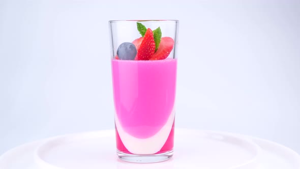 Fruit Jelly with Strawberries and Blueberries in a Rotating Glass on a White Background a Beautiful