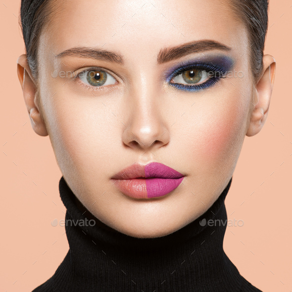 One half face of a beautiful white woman with bright makeup and the other  is natural. Stock Photo by valuavitaly