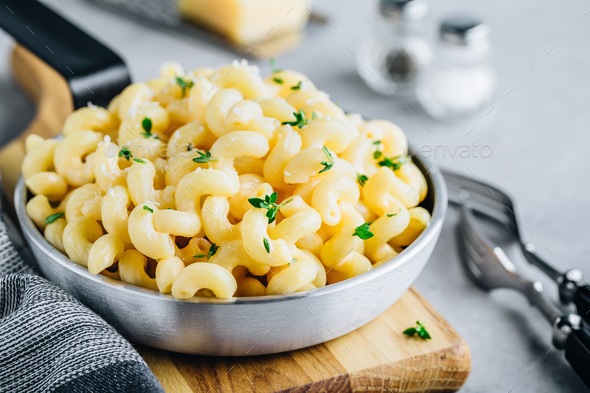 American mac and cheese, macaroni and cheese pasta in pan on gray stone background, copy space