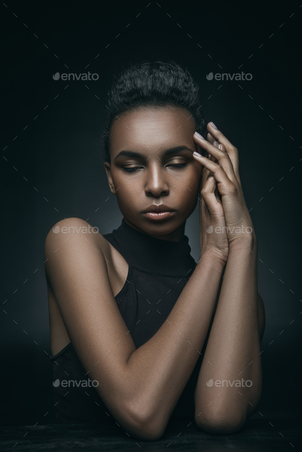 fashionable african american girl posing with closed eyes for fashion shoot,  isolated on grey Stock Photo by LightFieldStudios