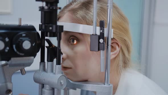 Optometrist Giving Slit Lamp Examination of the Eyes in Ophthalmology Clinic alt