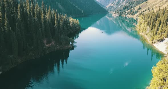 Beautiful landscape of mountain lake, Emerald water surrounded by coniferous forest, autumn grass alt