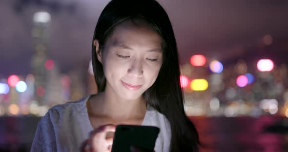Woman use of mobile phone in Hong Kong at night alt