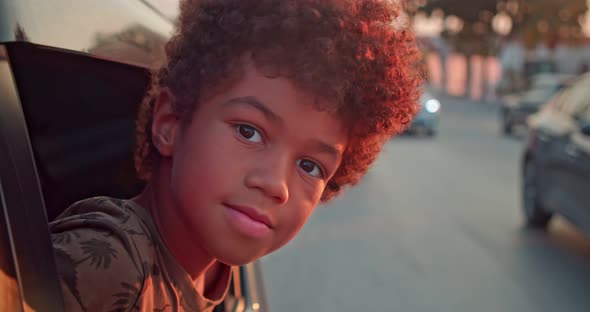 The Boy Looks Out of the Car Window and Looks Into the Camera Slow Motion Shooting at Speed alt