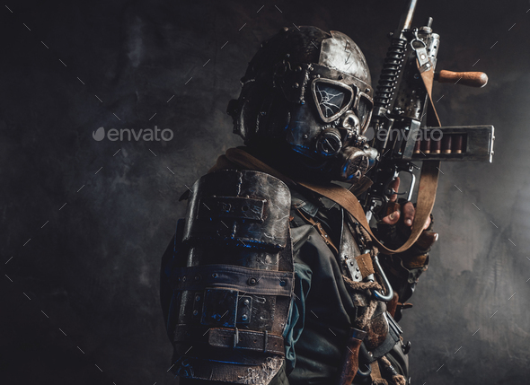 Grimy hunter with gas mask and custom gun in dark background