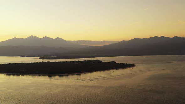 Gili Islands, Beautiful misty sunrise over the calm sea water, small islands and mountains in the ba alt