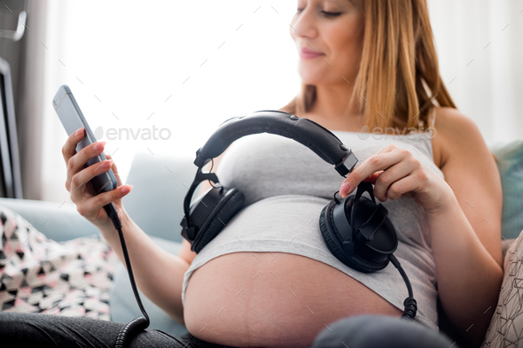 pregnant woman holding headphones on her belly. Music for baby. concept pregnancy  and music. Stock Photo