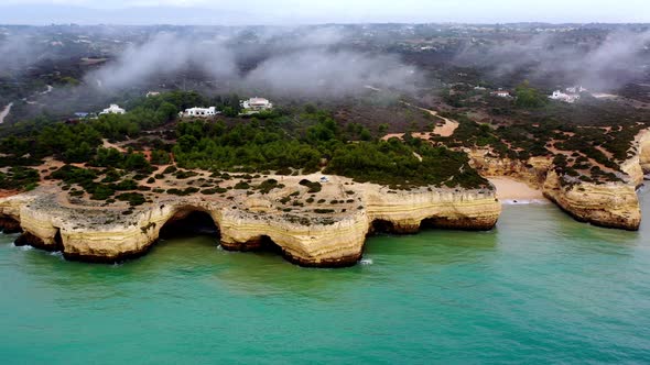 Fontainhas Beach in Portugal with camping van parked above sea carved caves, Aerial approach shot alt