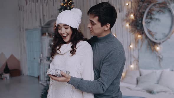 Young Man Coming From Behind Puts His Hand in His Girlfriend's Eyes and Surprises Her with a alt