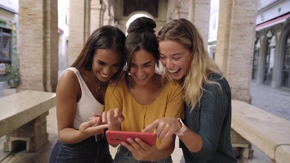 Three Happy Women Using Mobile Phone Outdoors alt